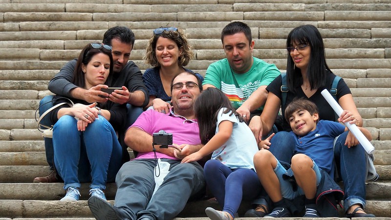 A family enjoying a selfie portrait on the steps of the cathedral in Girona, Costa Brava